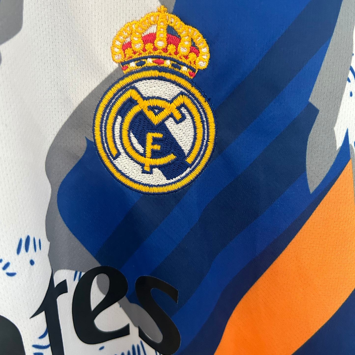 Real Madrid blue and orange football kit by ELVN, featuring team crest and matching jersey design on a white background.