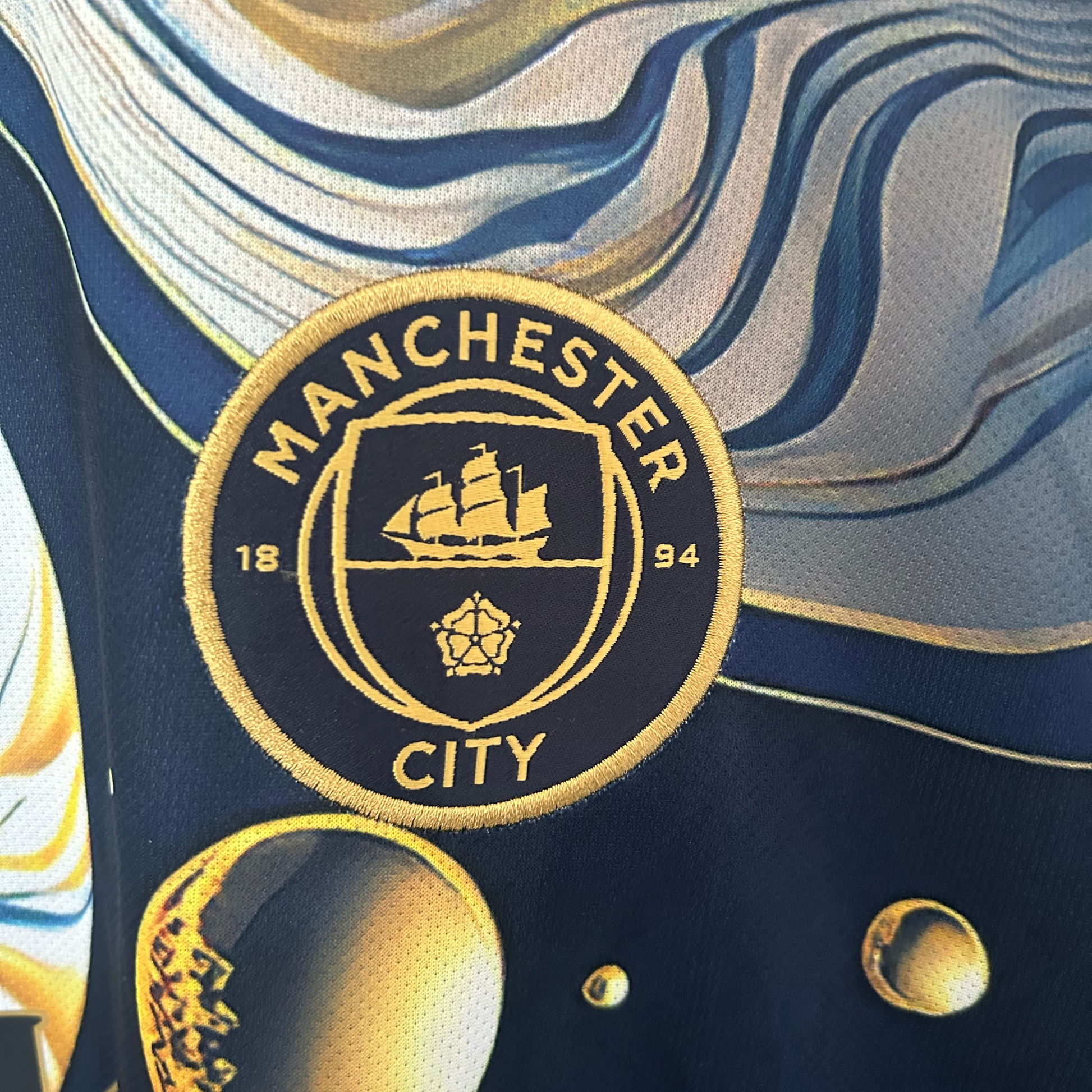 Manchester City galaxy kit by ELVN showing a vibrant blue jersey with galaxy-inspired patterns and team logo.