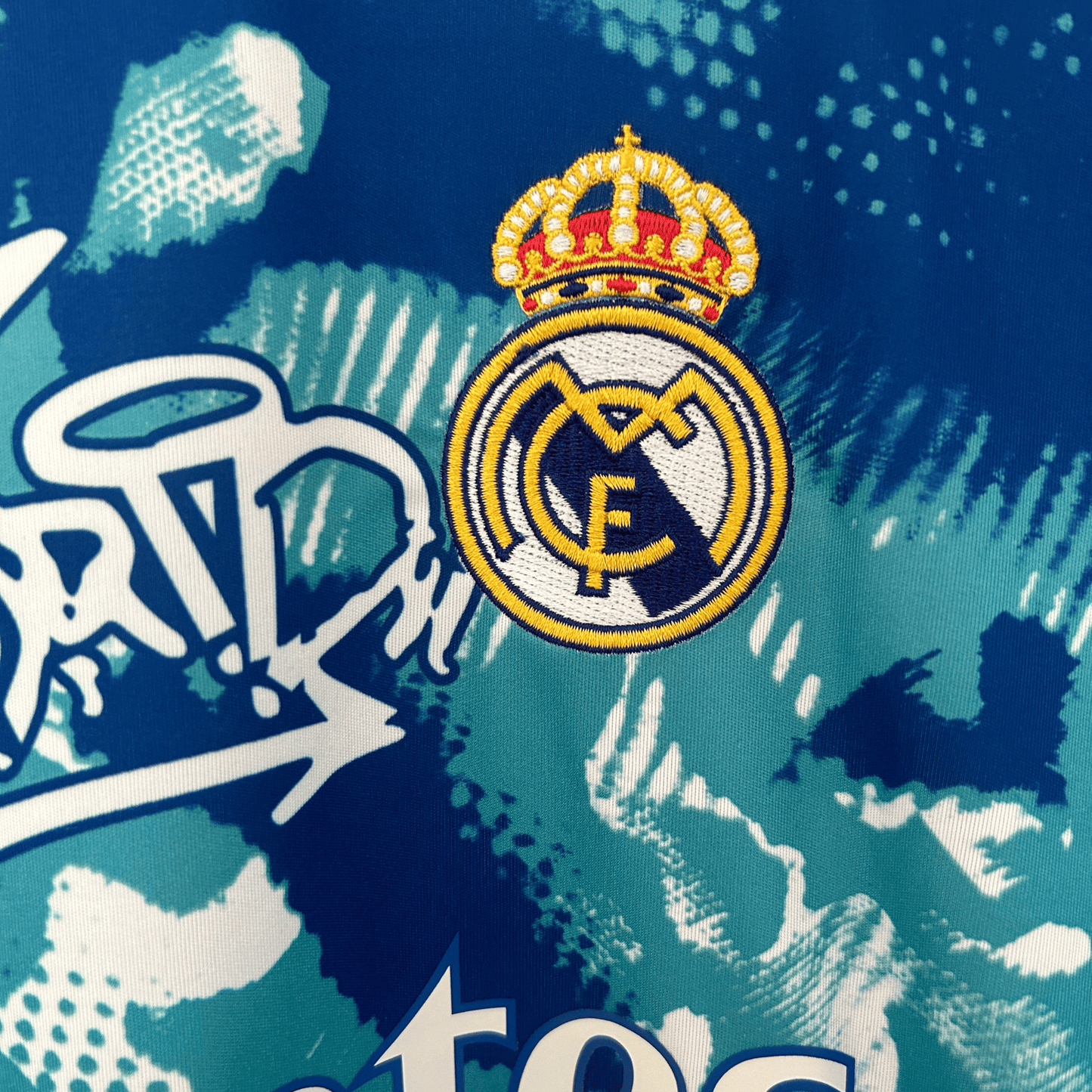Real Madrid blue and white camouflage kit by ELVN, featuring the team jersey with distinctive pattern and logo details.