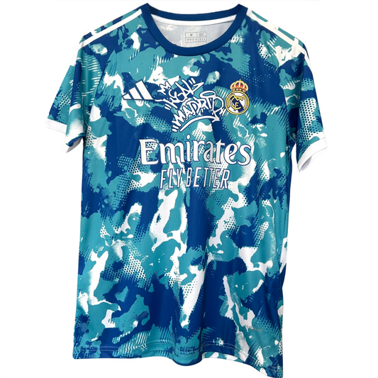 Real Madrid blue and white camouflage kit by ELVN, featuring the team jersey with distinctive camo pattern and team logo.